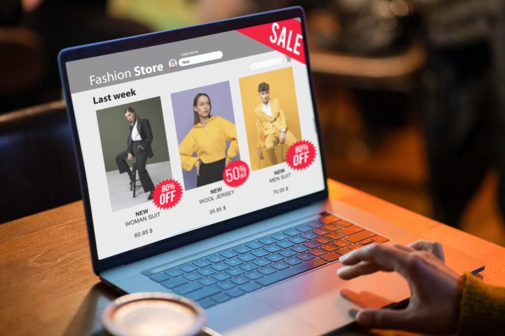 Is Investing in SEO Worth It for a Fashion Ecommerce Business? 3 A person browsing an online fashion store on a laptop, displaying discounted clothing items with sale tags.