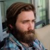 Technical SEO Company 4 A man with a full beard and a man-bun wearing black sunglasses and a red checkered flannel shirt, looking thoughtfully to the side
