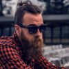 Technical SEO Company 2 A man with a long beard and a man-bun wearing black sunglasses and a red and black checkered flannel shirt looking off to the side.